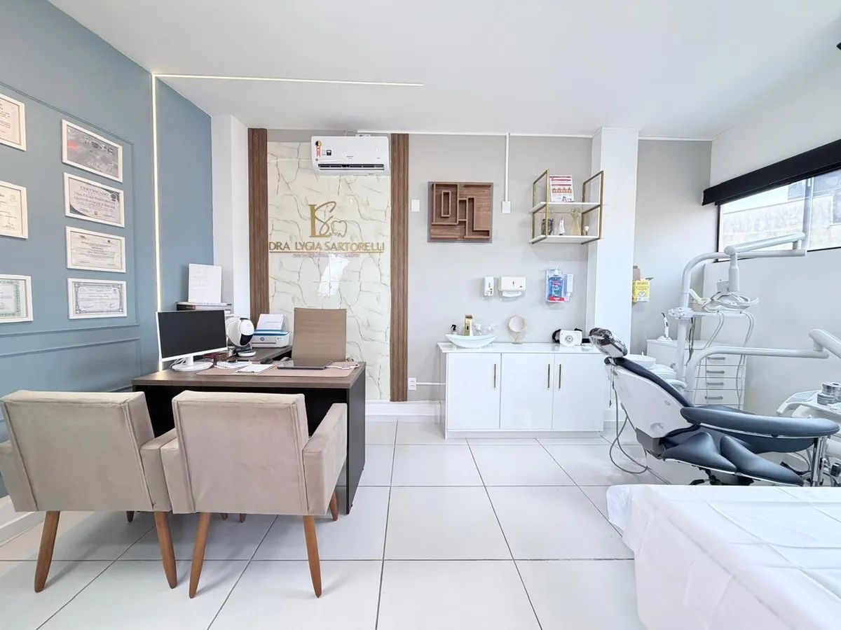 Consultório da Dra. Lygia Sartorelli em Itupeva: recepção com a mesa de atendimento e, ao fundo, a cadeira odontológica